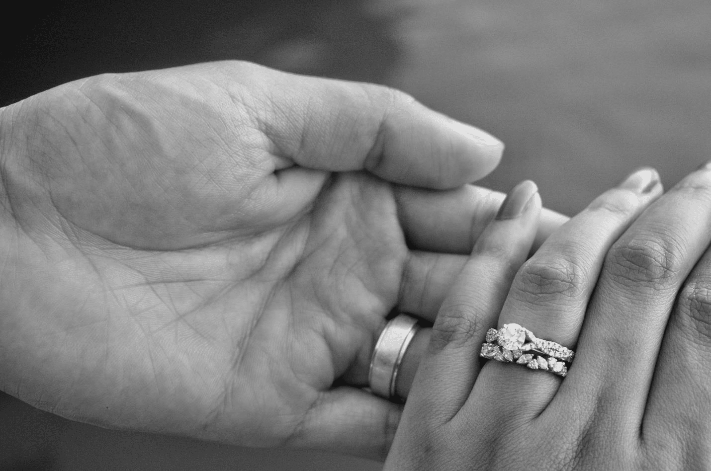 Man wearing a wedding ring and woman wearing a wedding ring and engagement ring