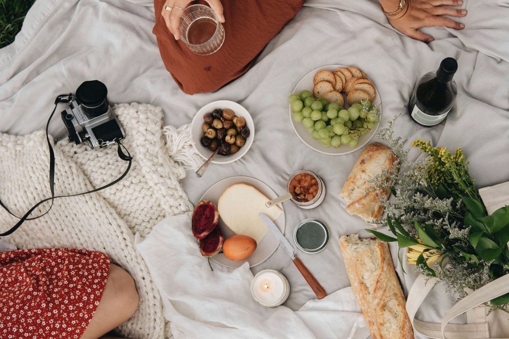 Food placed onto a picnic blanket.