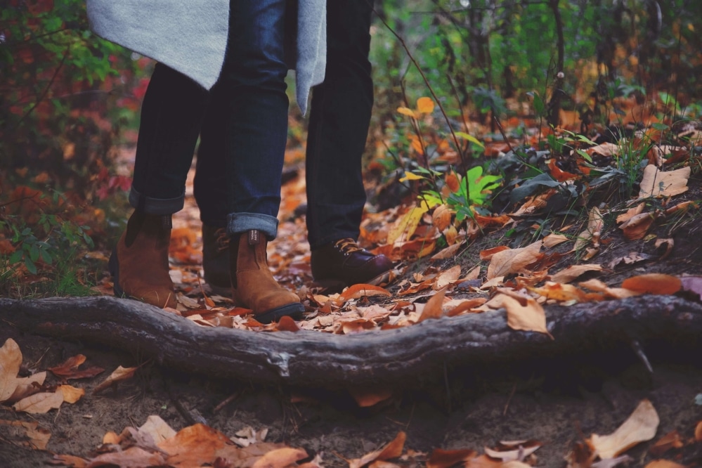 Couple walking over fall leaves.