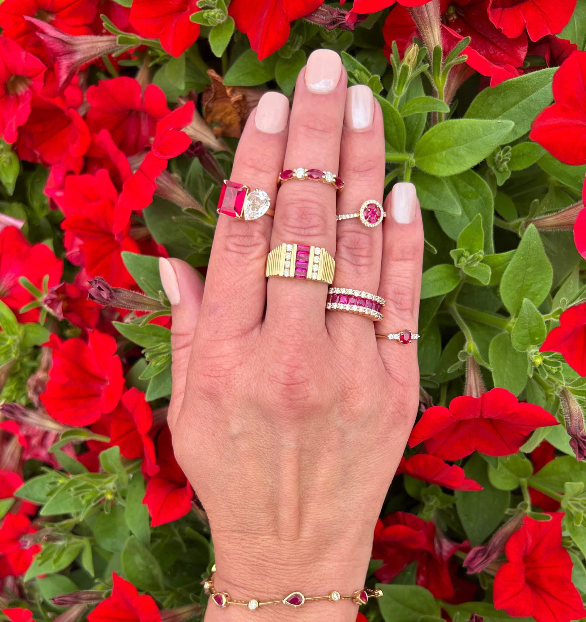 Woman's hand wearing ruby rings and a ruby bracelet